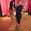 Two women posing together in a decorated room with red and white striped backdrop.