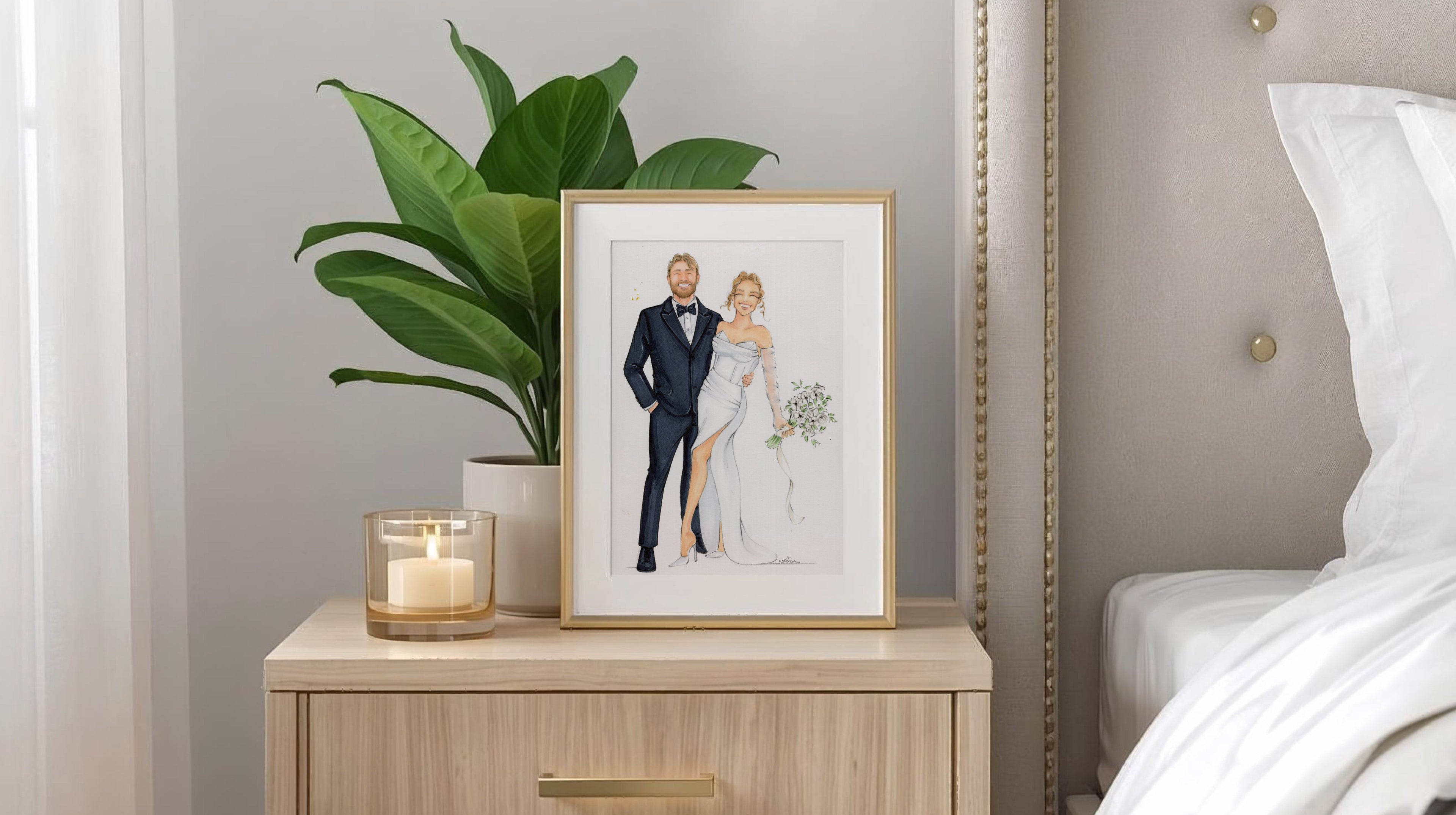 Framed artwork of a couple on a nightstand next to a bed with white bedding.