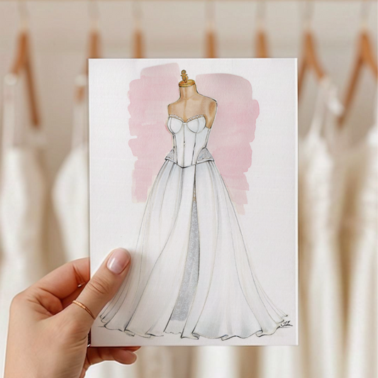 A hand holds wedding gown illustration featuring a soft pink watercolor wash behind it. The background shows a blurred boutique interior with hanging white dresses.